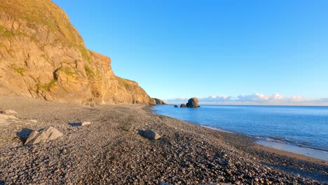 Zeitraffer:-Goldene-Stunde,-Sanfte-Meere-Plätschern-Am-Kiesstrand,-Sonne-Auf-Goldenen-Klippen