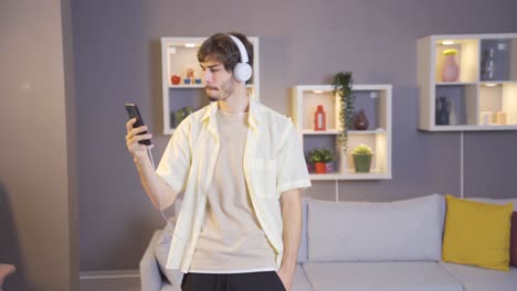 young man listening to music with headphones on his smartphone.