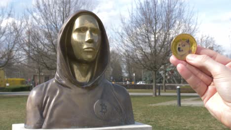 dogecoin token next to satoshi nakamoto statue