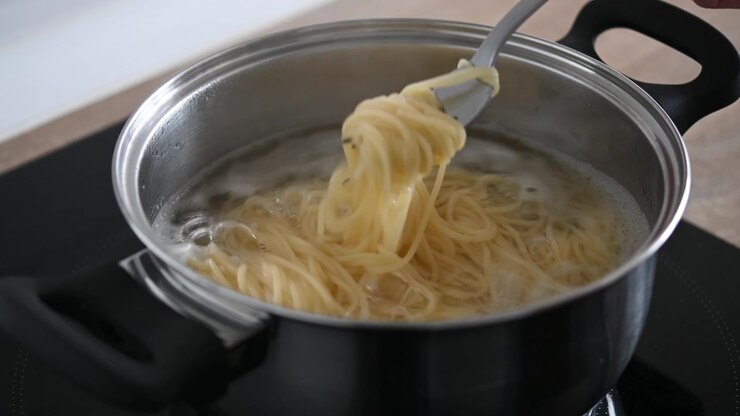 Mescolare gli spaghetti in una pentola di acqua bollente.