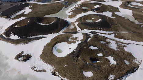 aerial view of snow capped volcanic hills and craters in landscape of iceland, drone shot