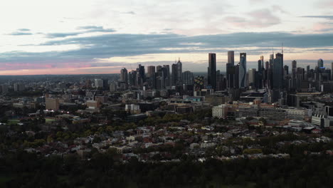 Cities-edge-meets-the-town-below,-Melbourne-aerial-drone-shot-in-early-morning