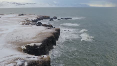 waves crashing on arnarstapi cliff and coastline in iceland