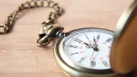 antique pocket watch on wooden surface