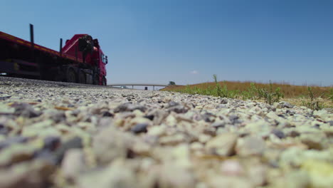 low angle view of cars driving on the highway, ground level, clear sky, agricultural bridge in the background