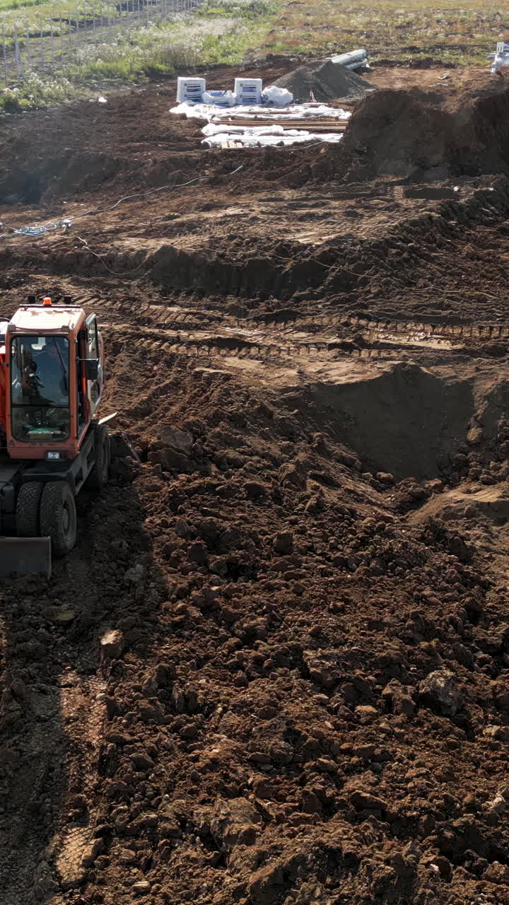 Uma escavadora laranja trabalhando em um canteiro de obras