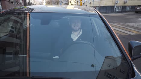 man driving a car in the city