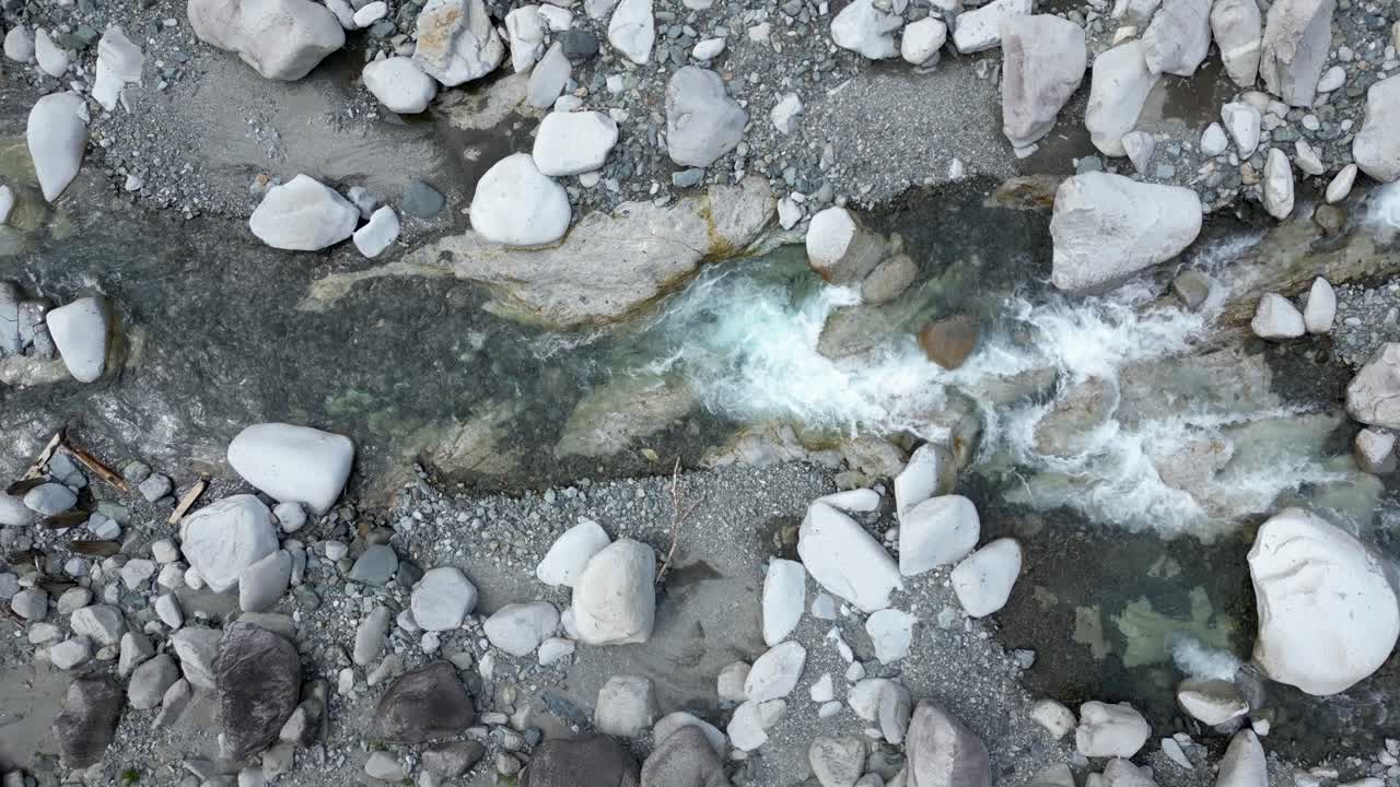 Droneoptagelse i slowmotion af klar, strømmende flod filmet fra oven