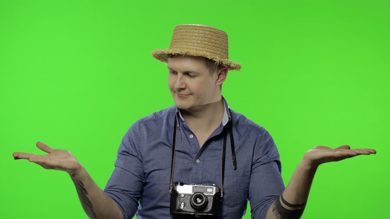 무언가를 가리키는 젊은 남자 관광 사진작가의 초상화.
