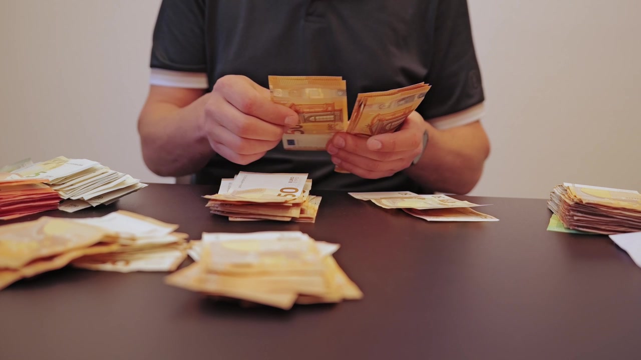 Slow motion cash counting symbolizes inflation anxiety and economic instability.