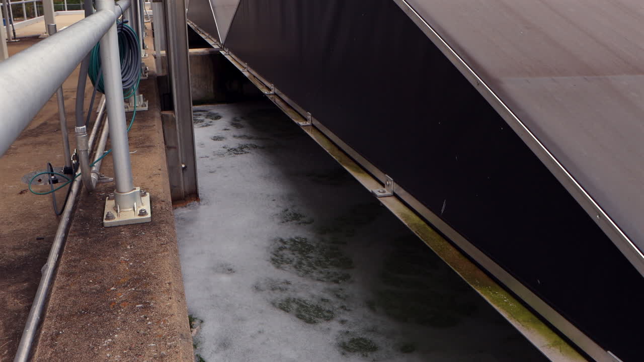 Wastewater churns in a UV-filter aeration basin, bubbles rising and rippling as the water is actively treated and purified