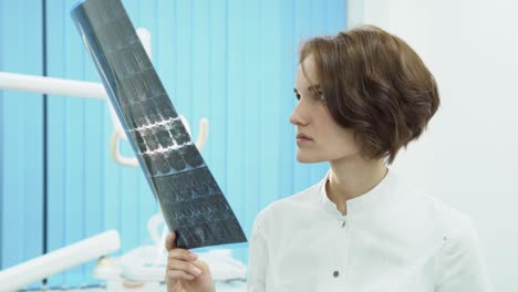 woman dentist reviewing x-ray