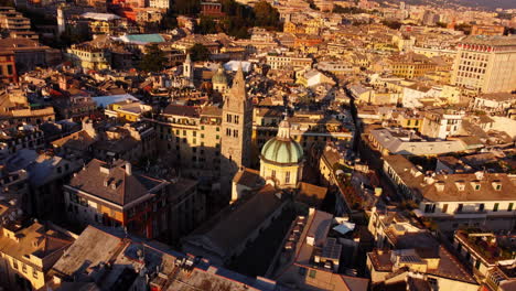 drone moving forward with tilt down over genoa’s historical center, focusing on san lorenzo cathedral at sunset