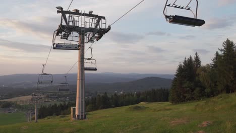 Panorama-with-closed-ski-lift-in-summer-before-sunset,-panning-left