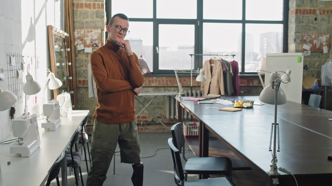 Estilista de moda com perna protética posando em estúdio