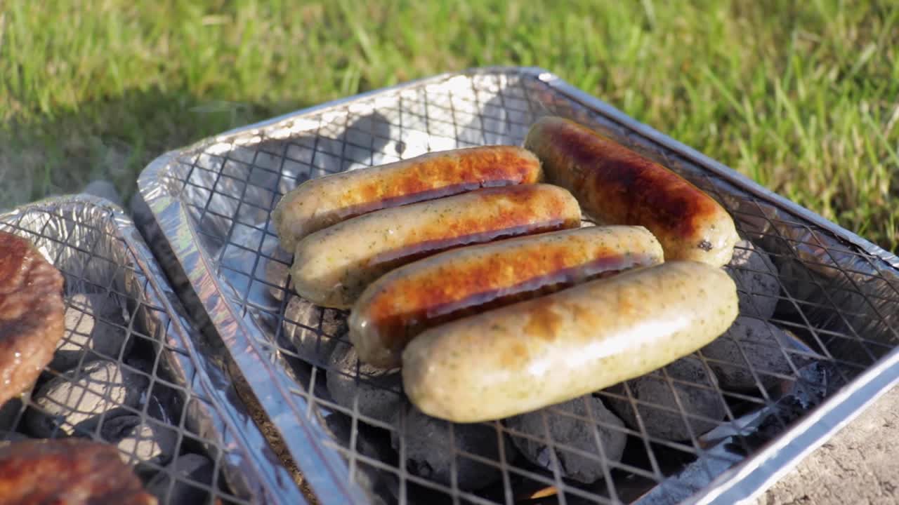 salchichas cocinadas en una pequeña barbacoa desechable.