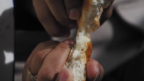 person tearing bread