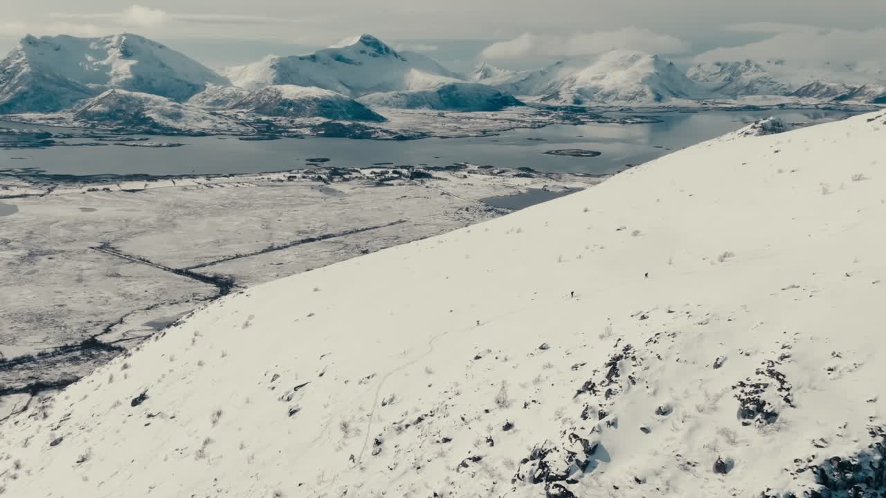Hikers On Steep Mountains Covered With Snow In Gimsoya Island, Vagan, Nordland County, Norway. Aerial Drone Shot