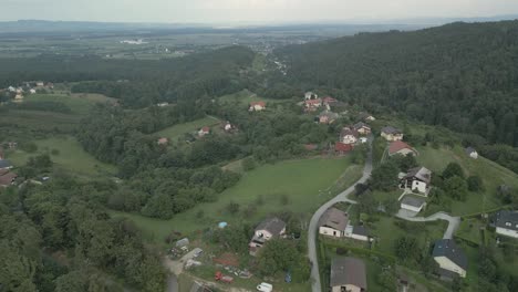 Breathtaking-drone-footage-soaring-over-Pohorje-hills,-revealing-charming-houses-nestled-amidst-scenic-beauty