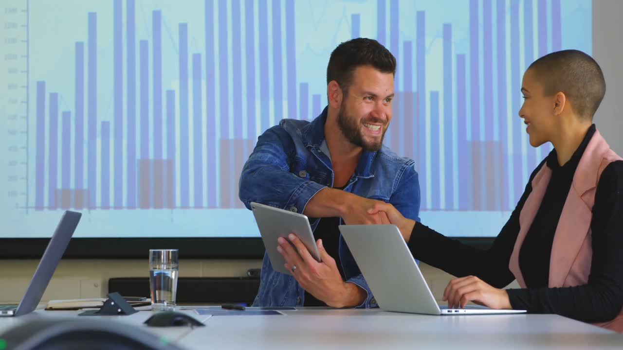 Jóvenes colegas de negocios caucásicos dándose la mano en la oficina 4k