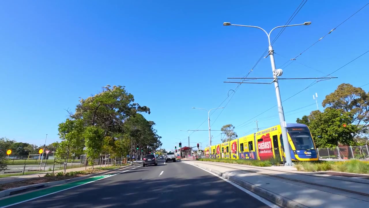 Toma en primera persona conduciendo por una carretera asfaltada bajo un cielo azul claro en Queensland, Australia