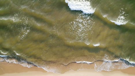 tropical beach aerial view, top view of waves break on tropical white sand beach. sea waves seamless loop on the beautiful sand beach.