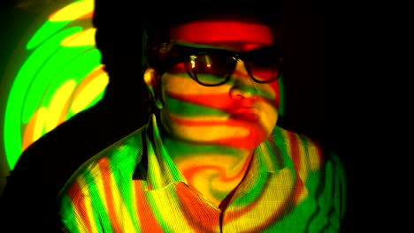 retrato de un hombre gordo en un haz de luz multicolor.