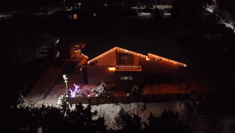 night aerial view of the house exterior lit and decorated with beautiful lighting during christmas