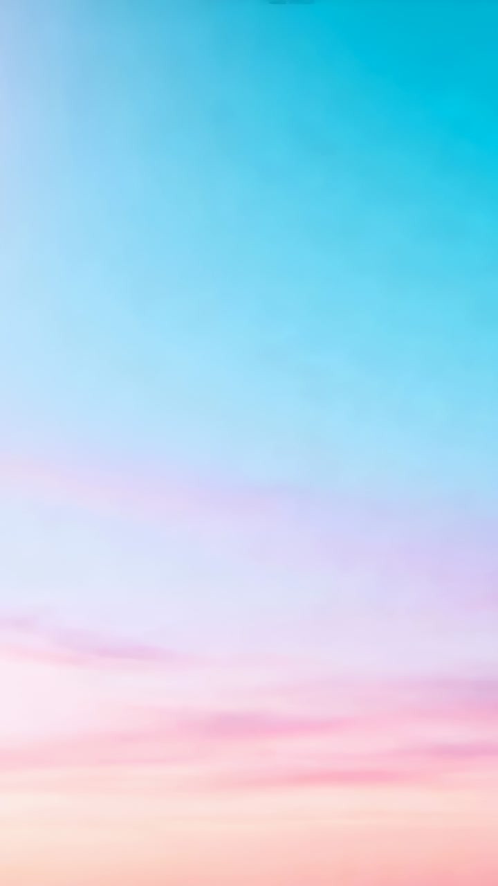 Vertical video: Shifting pastel sky with pink clouds drifting as frames advance at sunrise