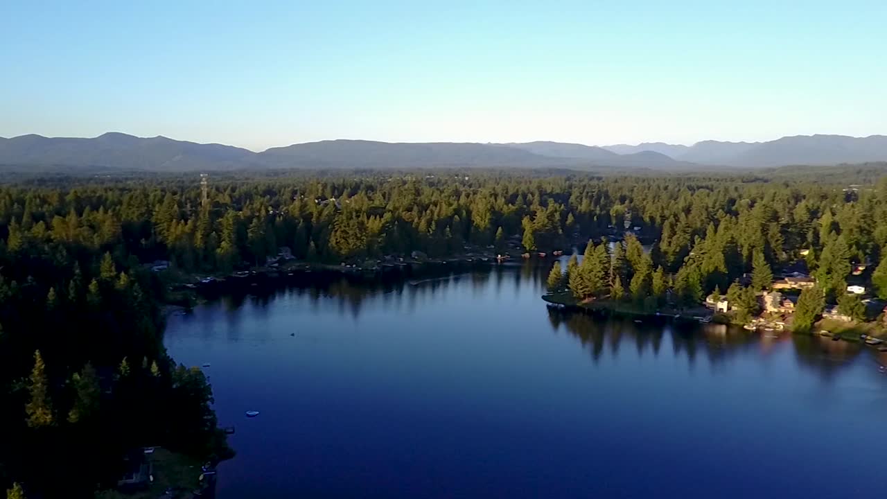 sereno paisaje de agua azul y follaje bajo un cielo despejado durante el invierno en pipe lake, washington