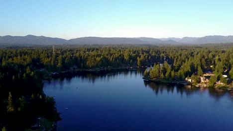 Serene-Blue-Water-And-Foliage-Landscape-Under-Clear-Sky-During-Winter-In-Pipe-Lake,-Washington