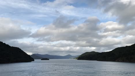 peaceful bay area in new zealand under a cloudy sky, concept of serene nature, calm waters, scenic coastline, untouched wilderness, and remote island tranquility.