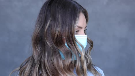 A-woman-walks-up-to-the-camera-wearing-a-mask-during-the-Covid19-coronavirus-pandemic-epidemic