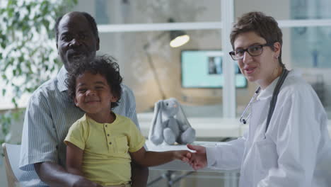 doctor examining child with grandfather