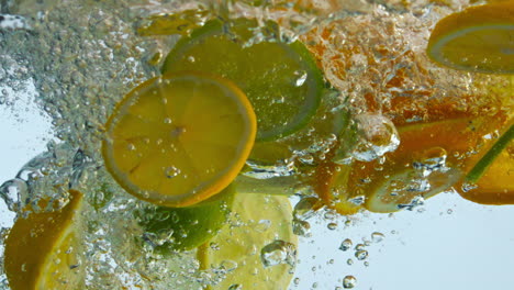 rebanadas de cítricos con agua burbujeante en un primer plano súper lento. mezcla naranja con limón