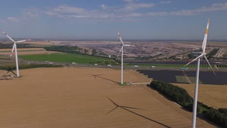 wind park overlooking solar panels and open-pit coal mining in juchen, germany