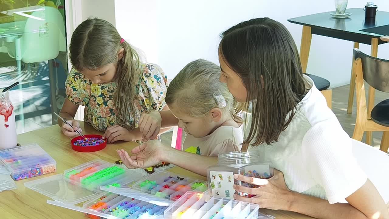 madre e hijas haciendo arte de cuentas juntas