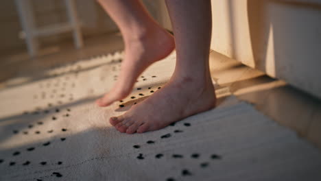 woman legs stepping bed in sunlight closeup. unknown woman wake up early morning