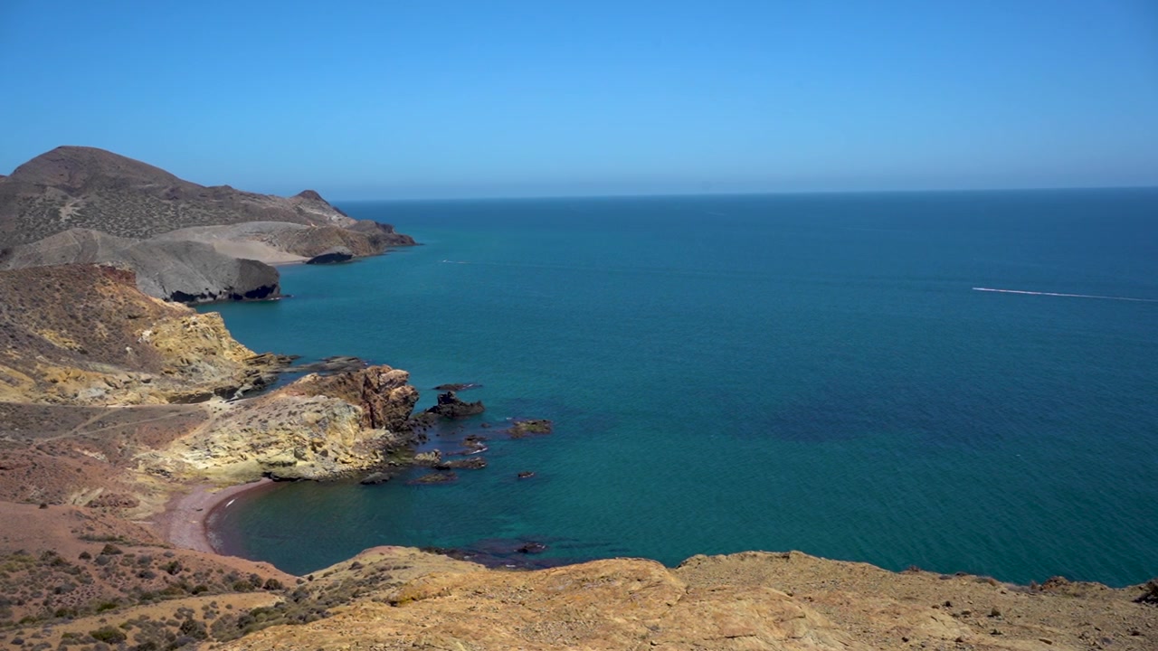 Scogliere costiere che si affacciano sul mare blu in una giornata limpida e soleggiata evocano serenità