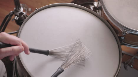 jazz drummer plays snare drum with brushes, overhead in slow motion