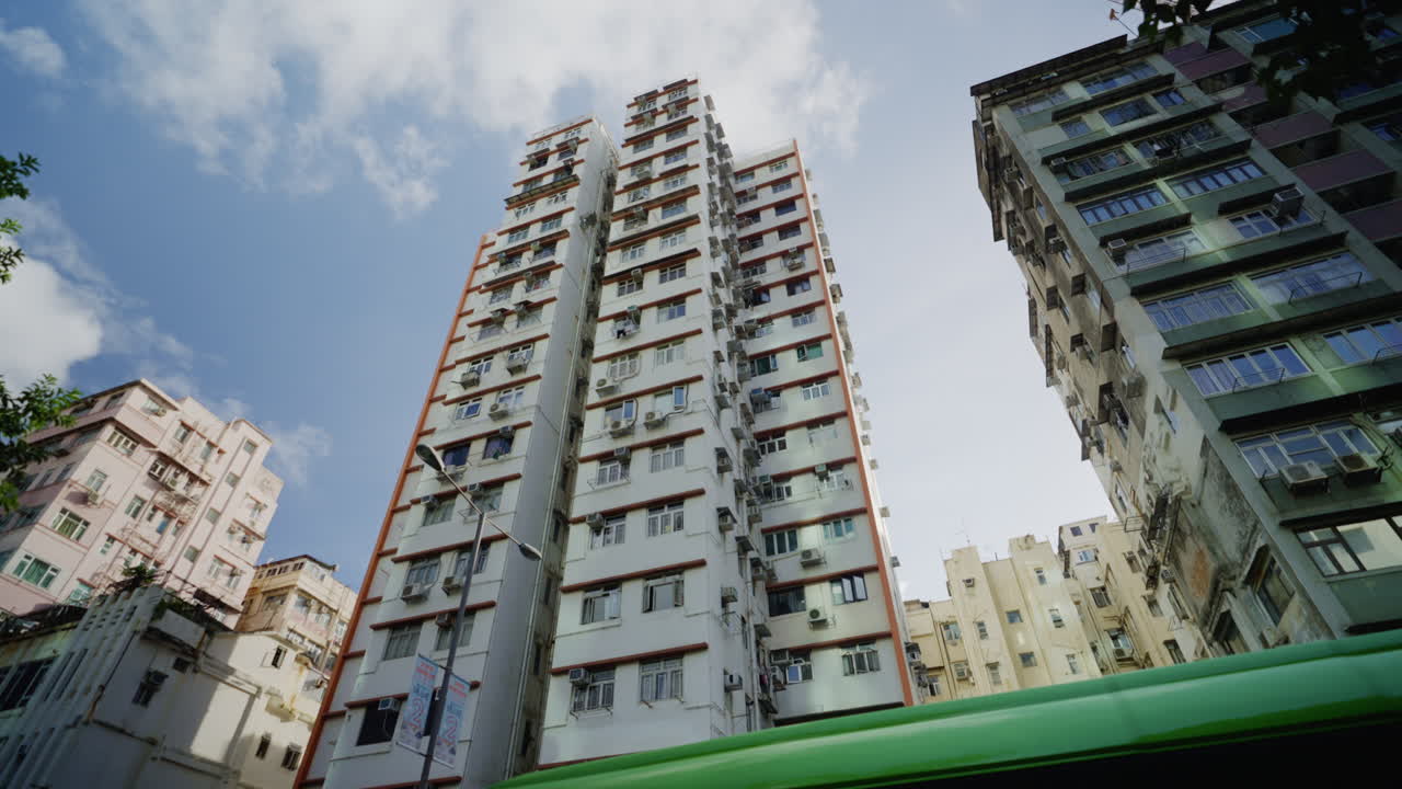 밝은 날에 나무와 함께 인상적인 층 건물의 낮은 각도 이동  ⁇