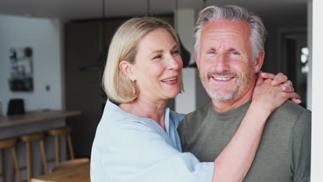 portrait of loving senior couple standing in kitchen together