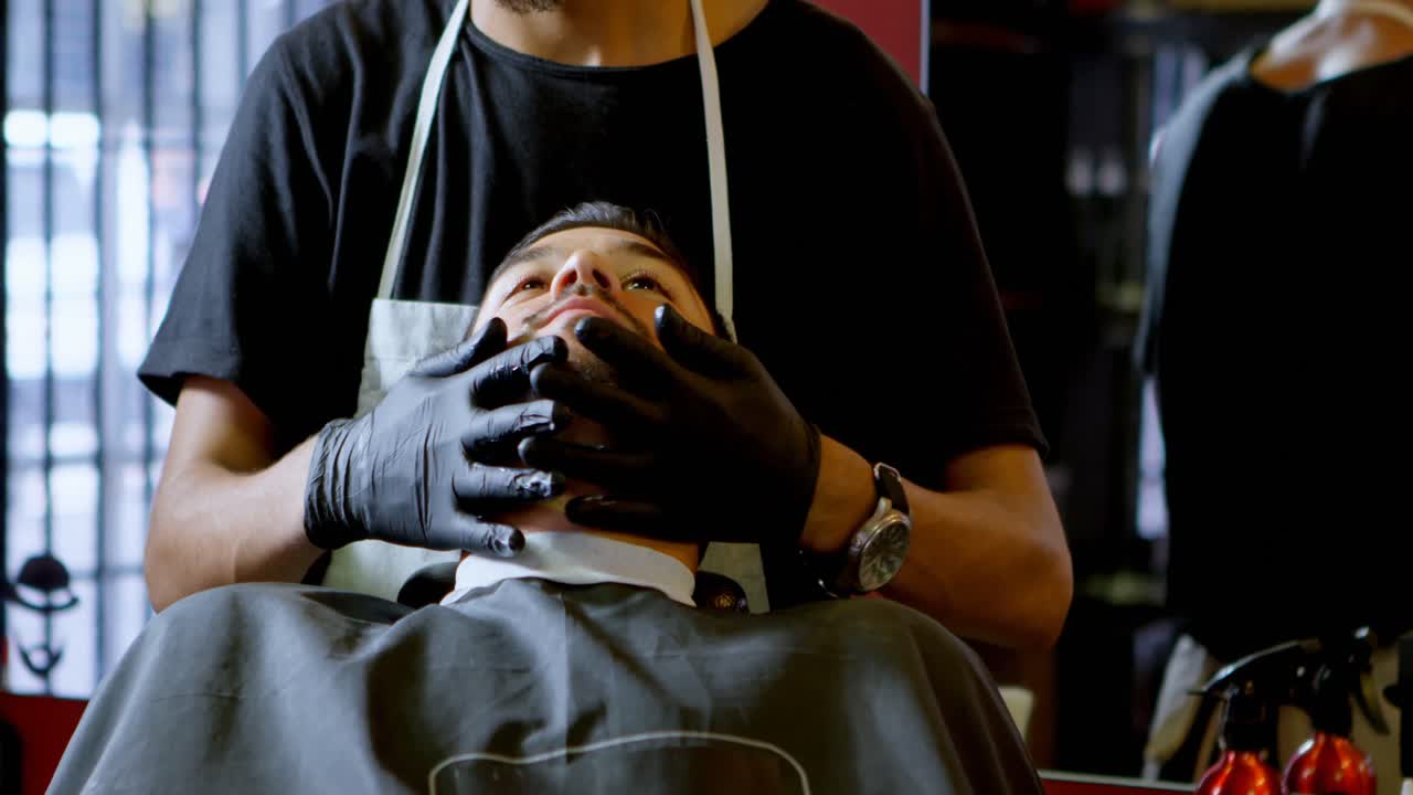 Barber smører kundens hud ind før barbering 4k