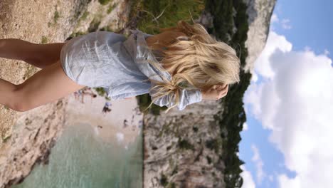 blonde girl at vantage point overlooking nugal beach makarska croatia, vertical