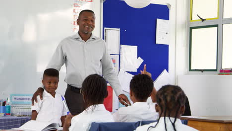 teacher and schoolboy in front of elementary school class