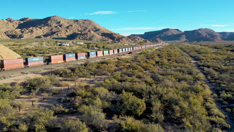 largo tren de carga que transporta carga a través del desierto de arizona a lo largo de la autopista 66