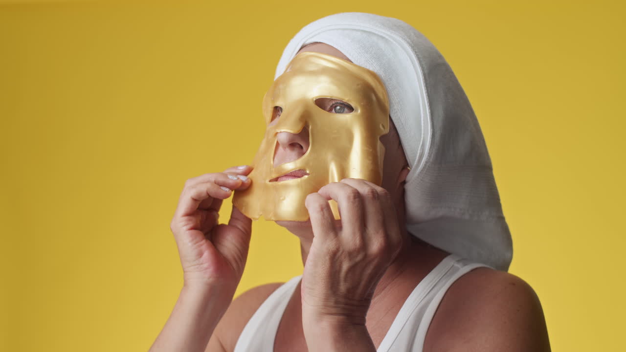 Middle-aged Woman Using Collagen Golden Facial Mask