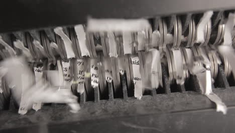 shredder cutting paper from below, two sheets, pan left to right