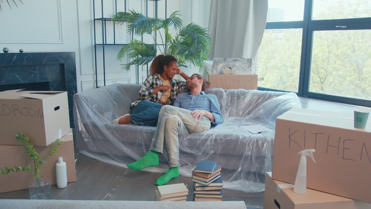 una pareja disfruta de momentos acogedores mientras desembala cajas en su nuevo hogar.