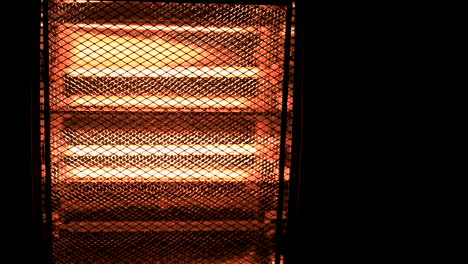 slowmotion cinematic shot of turning on electric halogen heater in the dark with copyspace